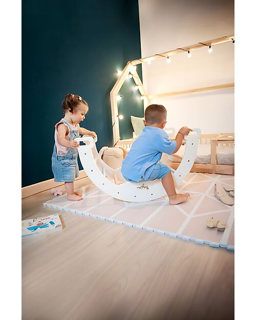 Due bambini giocano insieme con l'arco Montessori Family Nation nella loro cameretta